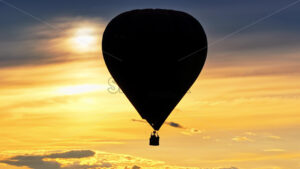 VIDEO Aerial drone view of a hot air balloon flying above the clouds at sunset - Starpik