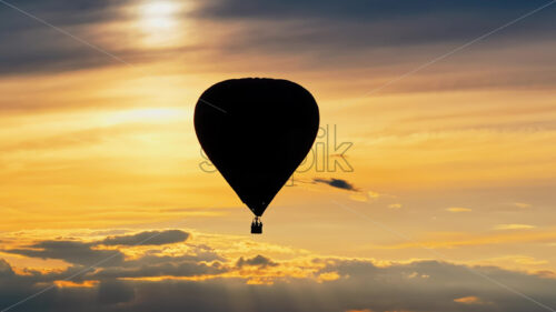 VIDEO Aerial drone view of a hot air balloon flying above the clouds at sunset - Starpik