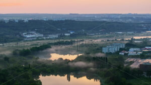 VIDEO Aerial drone view of a lake surrounded by trees in Chisinau, Moldova at sunrise - Starpik