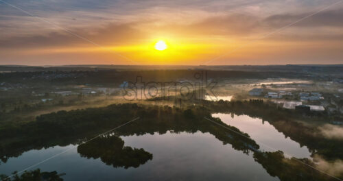 VIDEO Aerial drone view of a lake surrounded by trees in Chisinau, Moldova at sunrise - Starpik