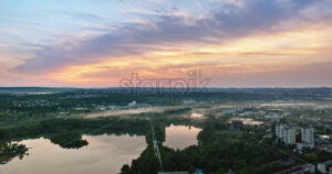 VIDEO Aerial drone view of a lake surrounded by trees in Chisinau, Moldova at sunrise - Starpik