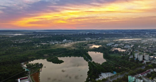 VIDEO Aerial drone view of a lake surrounded by trees in Chisinau, Moldova at sunrise - Starpik