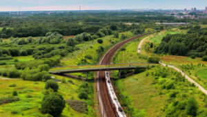 VIDEO Aerial drone view of a train moving on the rails towards a city - Starpik