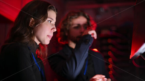 Royalty free stock video A man and a woman trying to fix an error in a server room with flashing red lights - Starpik