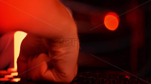 Royalty free stock video Close up of a man punching the keypad on a computer in a server room with flashing red lights - Starpik