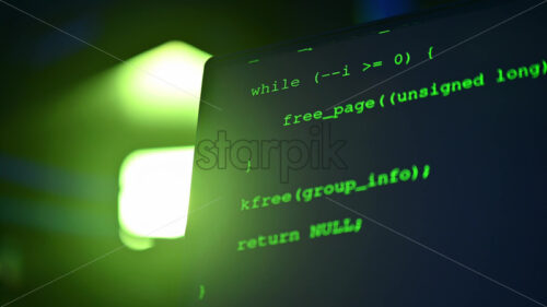 Royalty free stock video Close up of code on a screen in a server room with flashing red lights - Starpik