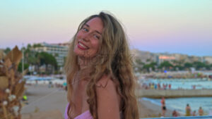 Royalty free stock video Woman in pink dress taking pictures at the beach in the evening in Cannes, France - Starpik