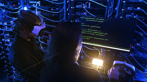 Royalty free stock video Woman programming in a server room while a man is using a Virtual Reality headset - Starpik