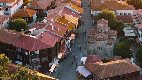 Royalty free video Aerial drone view of people moving through the old town Nessebar, Bulgaria at sunset - Starpik