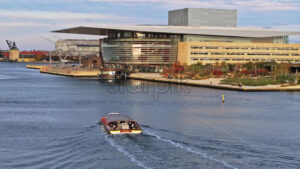 Video Aerial drone view of a boat passing by the Copenhagen Opera House in Denmark in daylight - Starpik