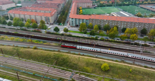 Video Aerial drone view of a train moving on the tracks near Vesterbro district in Copenhagen, Denmark - Starpik