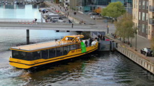 Video Aerial drone view of a yellow boat moving on the water in the Teglholmen peninsula in the South Harbour of Copenhagen, Denmark - Starpik