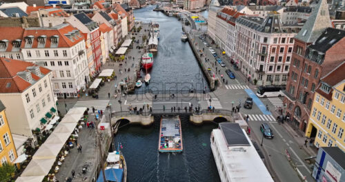 Video Aerial drone view of boats on the Nyhavn waterfront, canal and entertainment district in Copenhagen, Denmark in daylight - Starpik