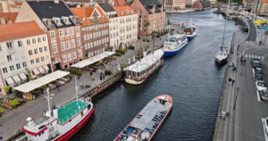 Video Aerial drone view of boats on the Nyhavn waterfront, canal and entertainment district in Copenhagen, Denmark in daylight - Starpik