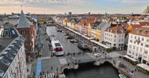 Video Aerial drone view of boats on the Nyhavn waterfront, canal and entertainment district in Copenhagen, Denmark in daylight - Starpik