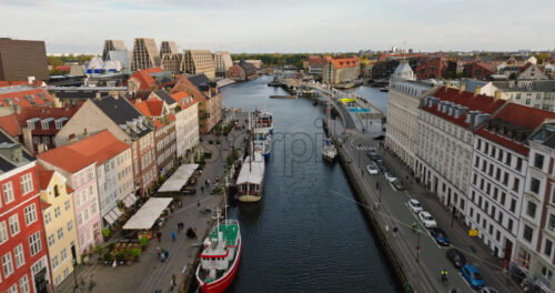 Video Aerial drone view of boats on the Nyhavn waterfront, canal and entertainment district in Copenhagen, Denmark in daylight - Starpik