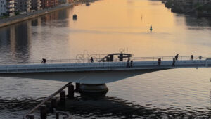 Video Aerial drone view of people moving on the Quay Bridge across the port of Copenhagen, Denmark in the evening - Starpik