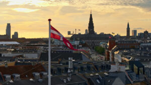 Video Aerial drone view of the Danish flag waving on top of a building in Copenhagen at sunset - Starpik