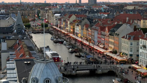 Video Aerial drone view of the Nyhavn waterfront, canal and entertainment district in Copenhagen, Denmark in the evening - Starpik