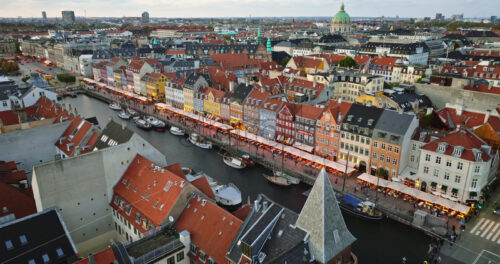 Video Aerial drone view of the Nyhavn waterfront, canal and entertainment district in Copenhagen, Denmark in the evening - Starpik