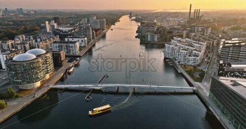 Video Aerial drone view of the Quay Bridge across the port of Copenhagen, Denmark at sunset - Starpik