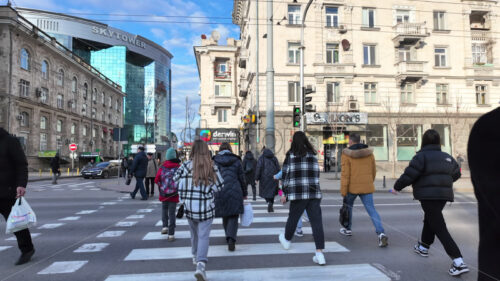 CHISINAU, MOLDOVA – MARCH 28, 2024: People crossing a pedestrian lane and walking on the streets of the city in daylight - Starpik