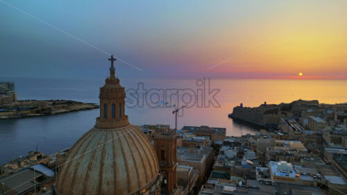 VIDEO Aerial drone view of the walled city of Valletta, Malta, surrounded by the Mediterranean sea in the evening - Starpik