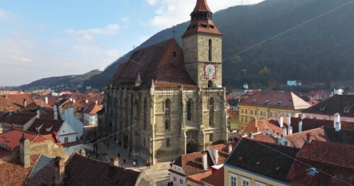 Video Aerial drone view of The Black Church in the city center of Brasov, Romania surrounded by mountains - Starpik