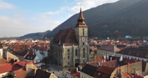 Video Aerial drone view of The Black Church in the city center of Brasov, Romania surrounded by mountains - Starpik