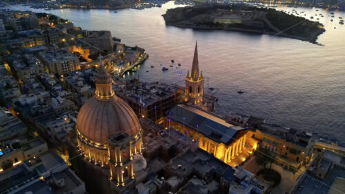 Video Aerial drone view of the walled city of Valletta, Malta, surrounded by the Mediterranean sea in the evening - Starpik