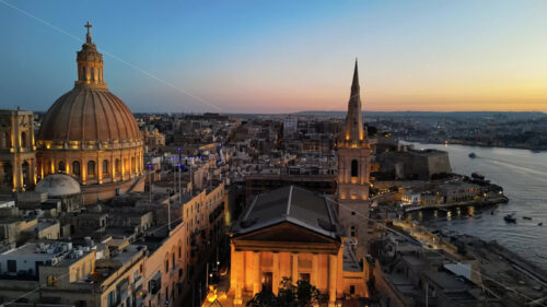 Video Aerial drone view of the walled city of Valletta, Malta, surrounded by the Mediterranean sea in the evening - Starpik