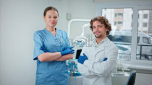 Video Two dentists wearing scrubs and standing and smiling in a dental cabinet, in front of a window - Starpik