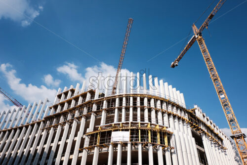 Abstract shape construction site with cranes at daylight - Starpik