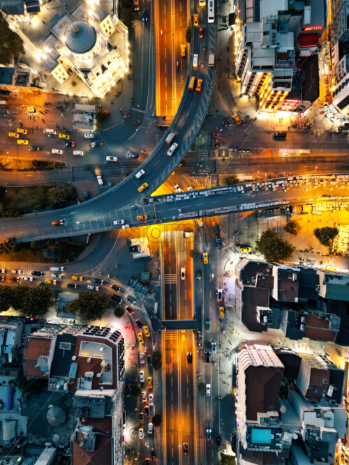 Aerial drone vertical view of Istanbul at night, Turkey. Residential buildings and roads with moving cars, nightlights - Starpik