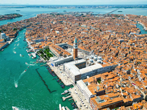 Aerial drone view of Venice, Italy. Water channels with multiple floating and moored boats, historical city centre with St Mark’s Square and other old buildings and narrow streets - Starpik