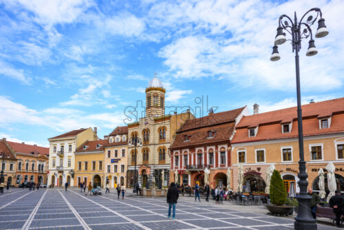 BRASOV, ROMANIA – OCTOBER 27, 2018: Historical architecture buildings in the old city square. People exploring local beauties - Starpik