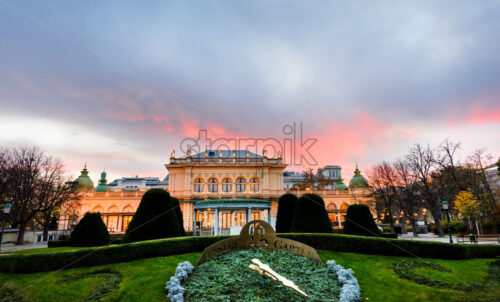 Beautiful bright red sunset view to Stadtpark Garden in cloudy day, green clock. Vienna, Austria - Starpik