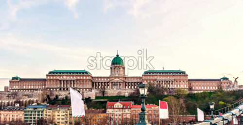 Buda Castle at sunset with warm cloudy sky. City buildings on bottom. Negative copy space, place for text. Budapest, Hungary - Starpik