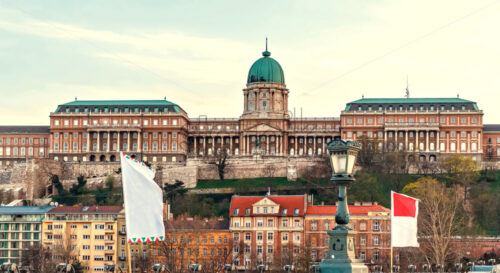 Buda Castle at sunset with warm cloudy sky. City buildings on bottom. Negative copy space, place for text. Budapest, Hungary - Starpik