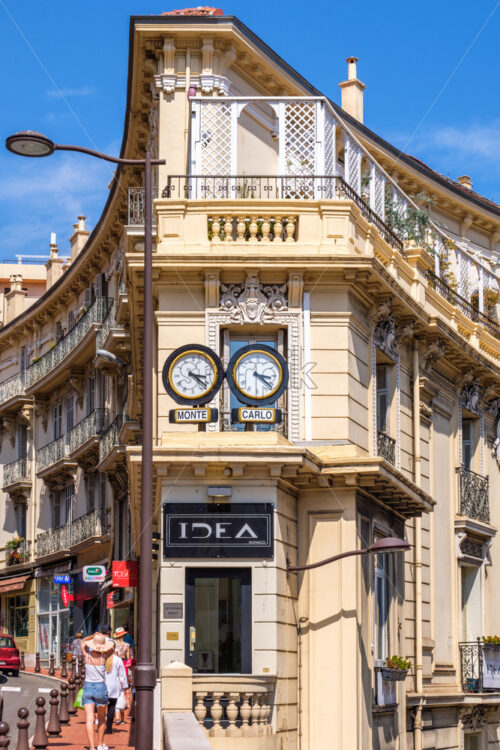 CANNES, FRANCE – AUGUST 07, 2018: Idea clocks creature on streets of Monte Carlo. People on promenade at daylight - Starpik