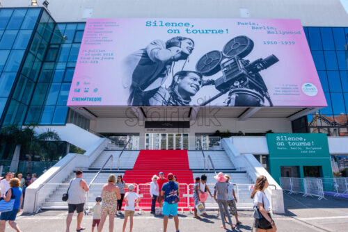 CANNES, FRANCE – AUGUST 12, 2018: Grand Auditorium theatre at daylight with people in front. Festival banner above - Starpik