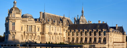 Chantilly Castle and Museum of Conde at sunset in France. Wide panoramic shot - Starpik