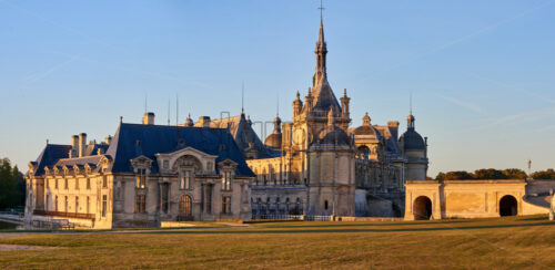 Chantilly Castle and Museum of Conde at sunset in France. Wide panoramic shot - Starpik