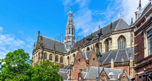 Church of St. Bavo from bottom in a sunny day. Bright blue sky with clouds on background. Negative copy space, place for text. Haarlem, The Netherlands - Starpik