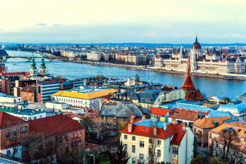 City and Danube River at sunset. Blue cold sky on background and warm sunlight reflecting on buildings. Parliament on background. Negative copy space, place for text. Budapest, Hungary - Starpik