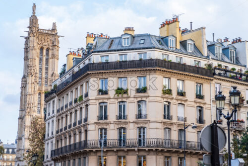 Colourful and sunny day in Paris. Close up shot in the center of the street to a tall tower and a restored building. French beauties - Starpik