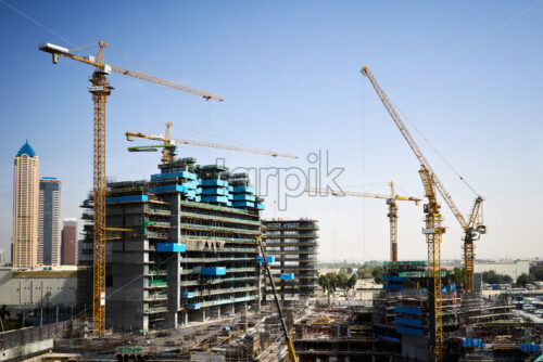 Construction site with cranes and people working. Dubai, United Arab Emirates - Starpik