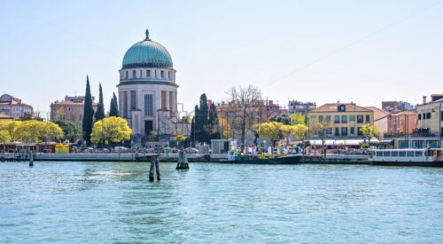 Daylight panoramic wide view from venetian lagoon to The Lido Of Venice church and a part of city. Bright blue clear sky. Negative copy space, place for text. Venice, Italy - Starpik