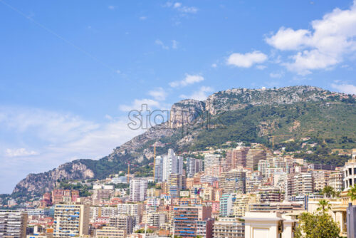 Daylight sunny view to city buildings and mountains with blue sky - Starpik