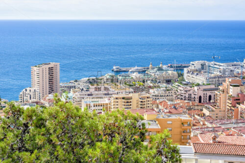 Daylight sunny view to yacht parked in port, luxury buildings and modern houses. Construction cranes working. Bright blue clear sky. Negative copy space, place for text. Monte Carlo, Monaco - Starpik